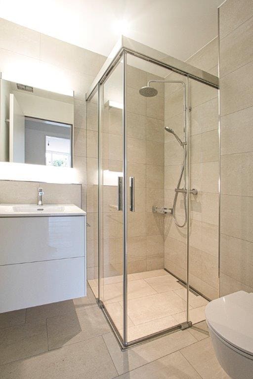 eca74132-d57f-48d4-bfbe-a88d54db5d1b Badezimmer mit hellen grossen Fliesen