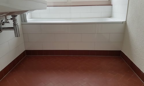 Altbau Badezimmer mit rostfarbenen Platten vor Sanierung