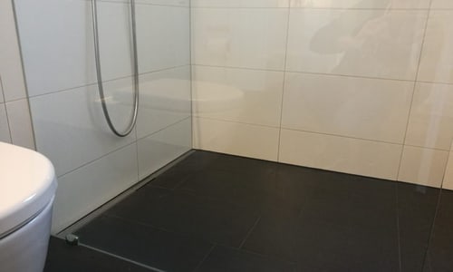 Dusche mit schwarzen Bodenplatten